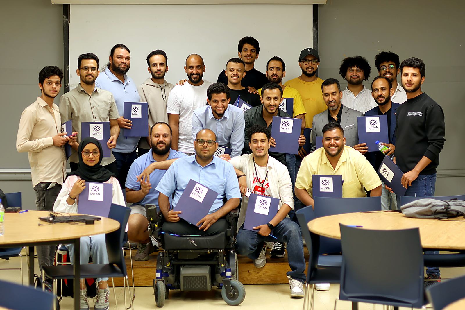 Participants holding Cayan folders after a community session
